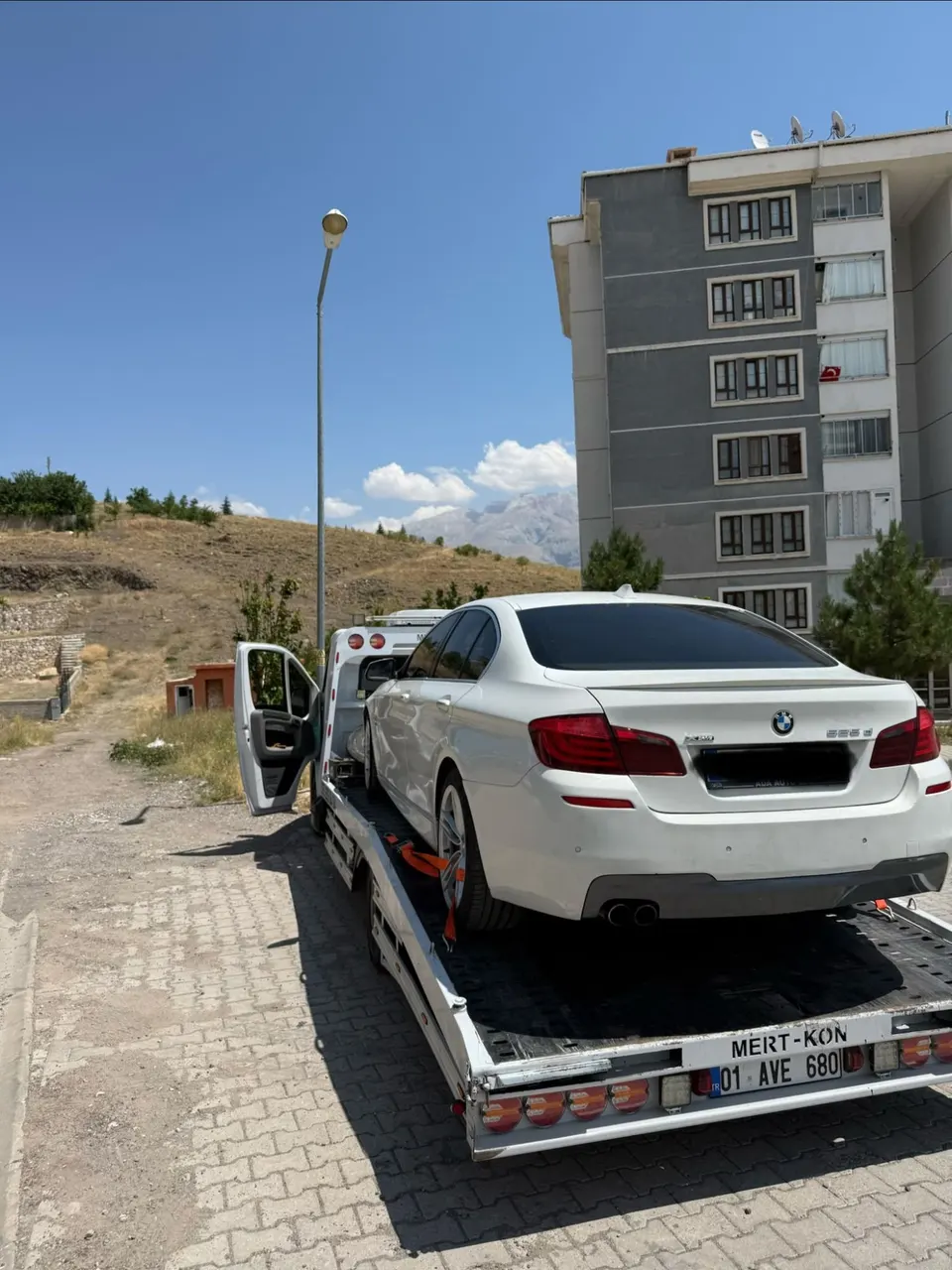 Kayar kasalı çekici üzerinde kayışlarla sabitlenmiş BMW, arkadan görünüm