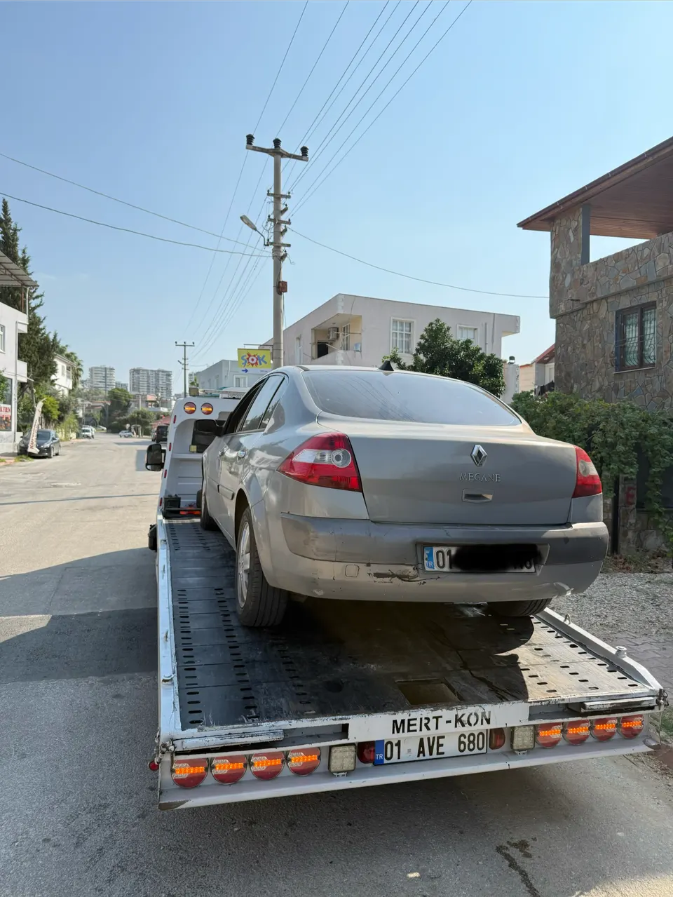 Kayar kasalı çekici üzerinde taşınan gri Renault otomobil